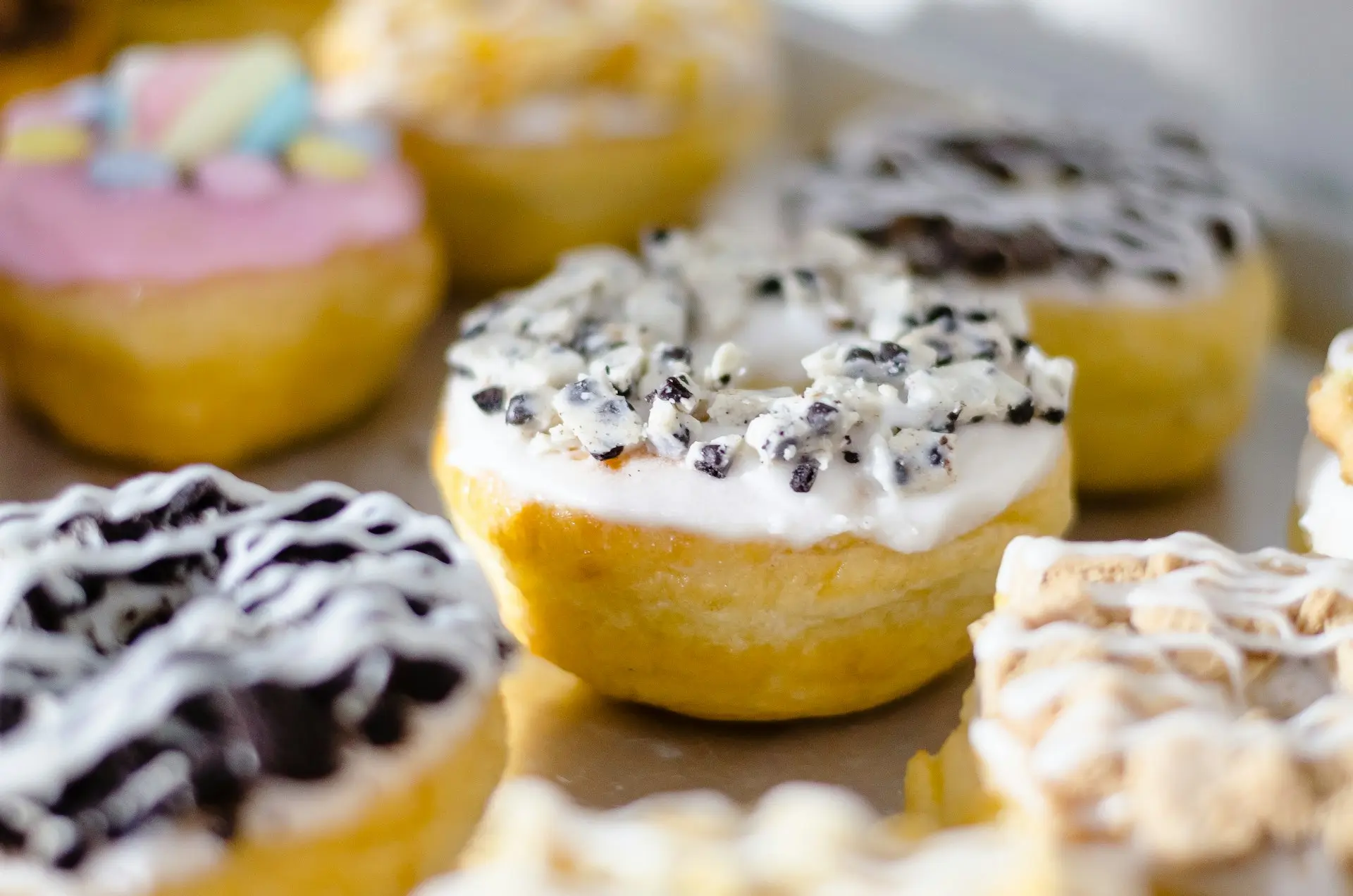donat kuning dan biru di atas piring keramik putih
